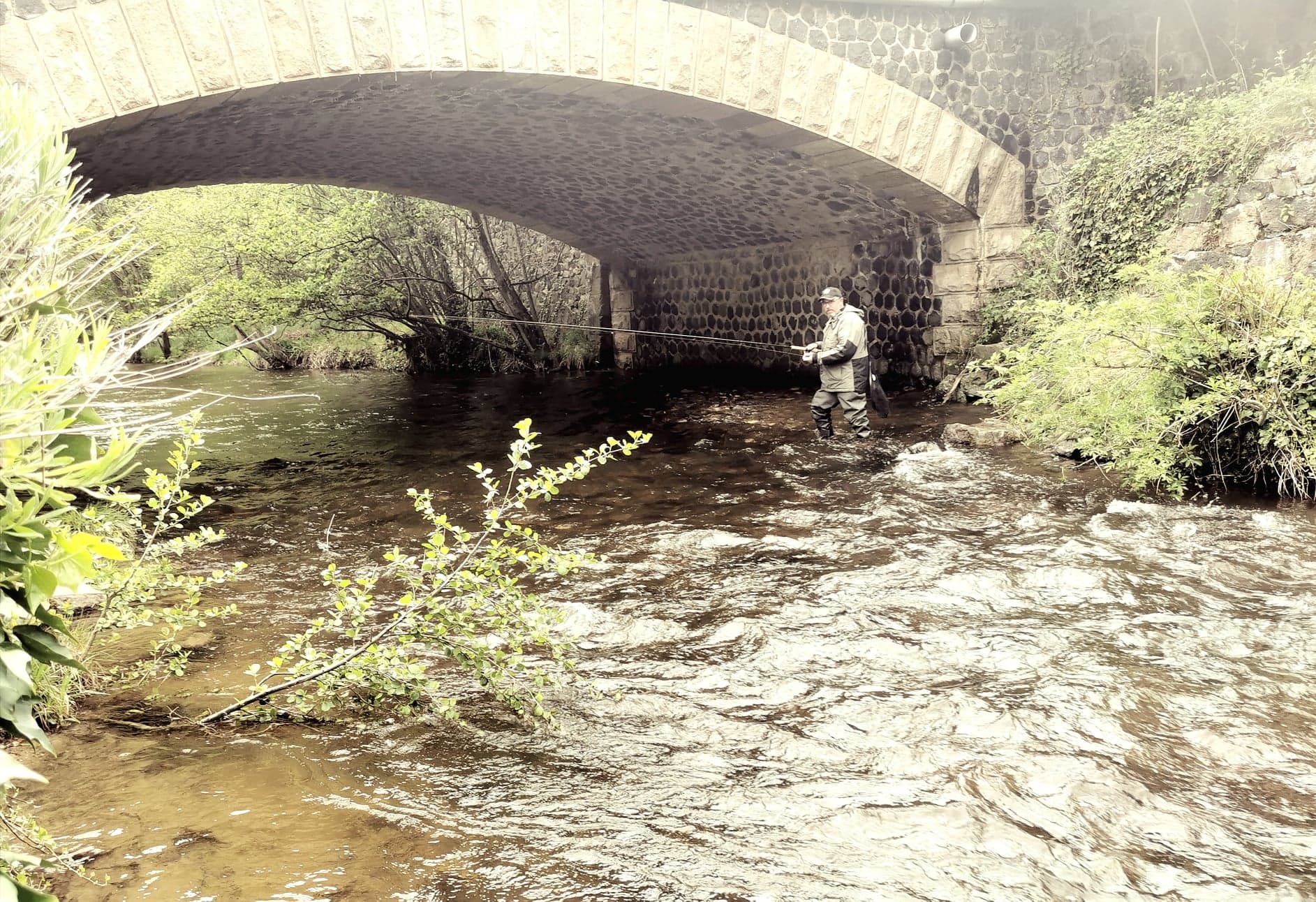 Fishing under the bridge in the garden of the Chanteuges inn